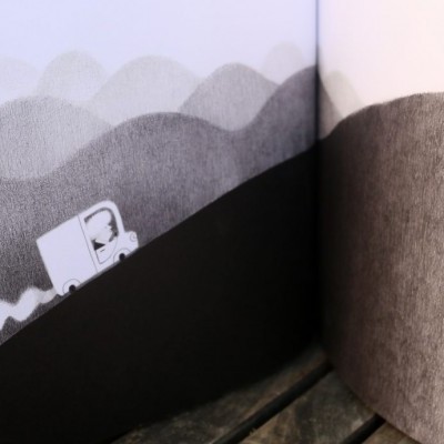 Página aberta de livro com ilustração em tons de cinza e preto de estrada sinuosa e placa de sinalização.