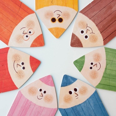 Peças de madeira coloridas com rostos desenhados em círculo