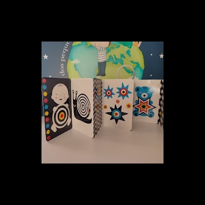 Livro para bebés com desenhos coloridos em fundo azul com estrelas e ilustração de crianças sobre o globo