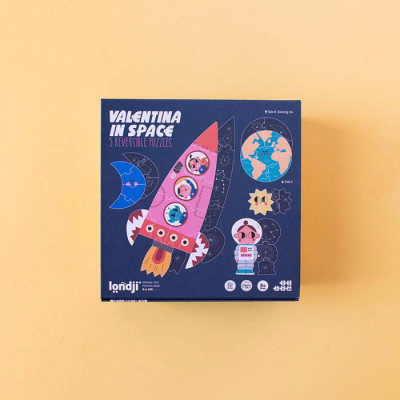 Caixa azul de puzzle reversível com tema espacial e personagens coloridos.