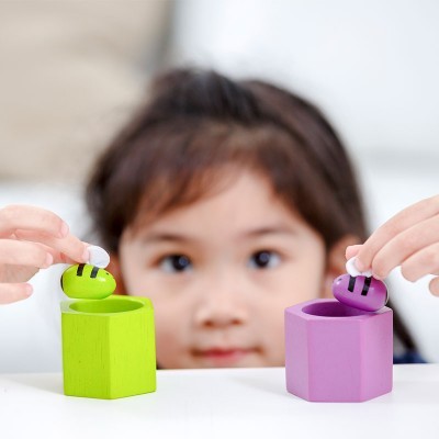 Dois recipientes hexagonais coloridos em madeira com figuras de abelhas em cima