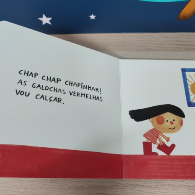 Página de livro infantil com texto e ilustração de menina a calçar galochas vermelhas