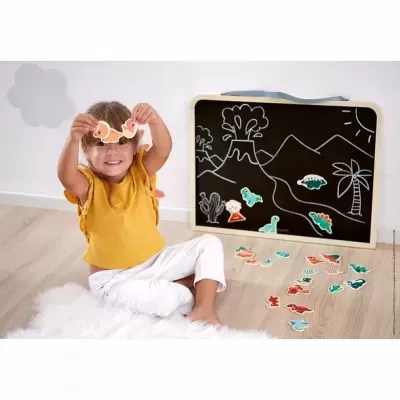 Criança a brincar com peças de dinossauros junto a um quadro-negro com desenhos a giz