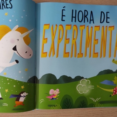 Página de livro infantil com ilustração colorida de unicórnio, ratinhos e sapo, texto em português