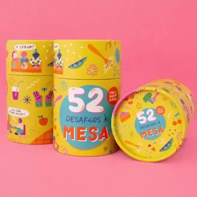 Latas amarelas com 52 desafios à mesa e ilustrações coloridas