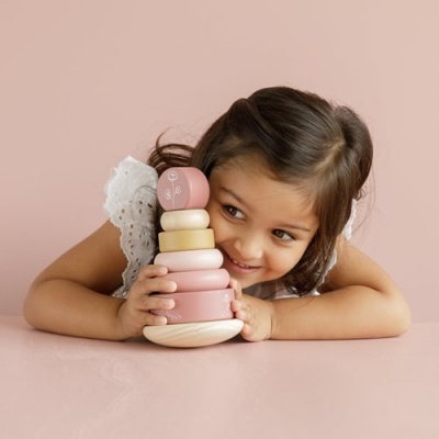 Criança a brincar com brinquedo empilhável de madeira em tons pastel