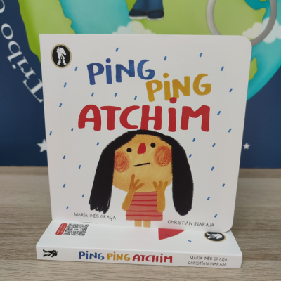 Capa de livro infantil 'PING PING ATCHIM' com ilustração de personagem e texto colorido