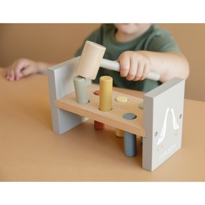 Brinquedo de madeira com martelo e pinos coloridos em mesa bege