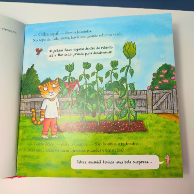 Página de livro infantil com ilustração colorida de gato e plantas altas com botões verdes em jardim