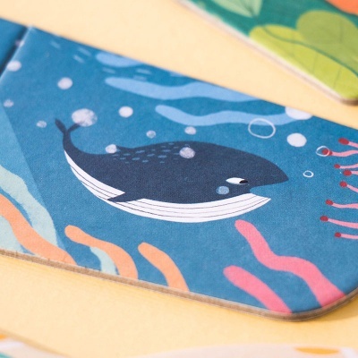 Base de mesa com ilustração de baleia azul e elementos coralinos coloridos