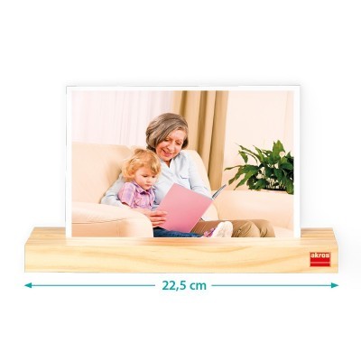 porta-fotos de madeira clara com fotografia inserida de mulher e criança a ler livro cor-de-rosa no sofá
