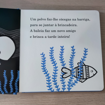 Página de livro infantil com texto em português e ilustração de peixe com padrões geométricos e algas azuis