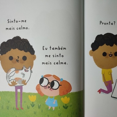Ilustração de crianças com gato e texto em português num livro infantil.