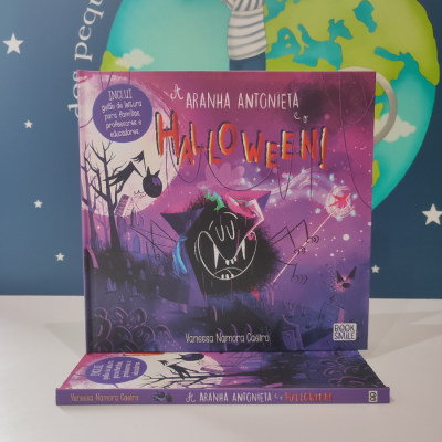 Capa de livro infantil 'A Aranha Antoinieta e o Halloween!' com ilustração de aranha, cores roxas e texto colorido
