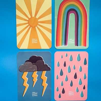 Quatro cartões coloridos com desenhos de sol, arco-íris, nuvens com relâmpagos e gotas de chuva sobre fundo azul