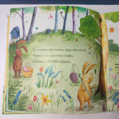 Página aberta de livro infantil com ilustração de coelhos numa floresta e texto em português