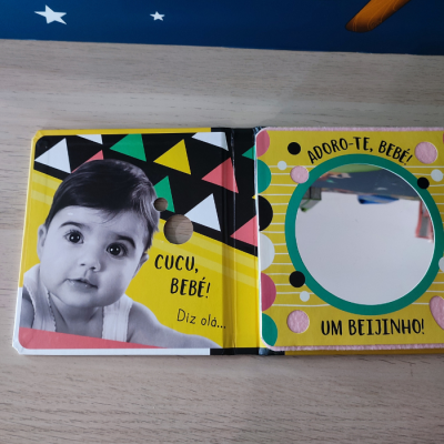 Livro infantil colorido com foto de bebé e espelho redondo