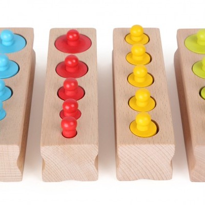 Brinquedos educativos de madeira com formas cilíndricas coloridas em bases retangulares