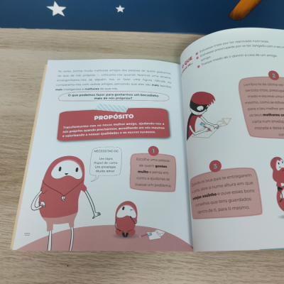 Livro aberto com ilustrações a cores e texto em português sobre propósito e autoajuda