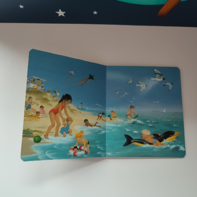 Livro infantil com ilustrações de crianças na praia e no mar