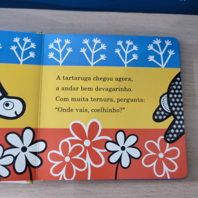 Livro infantil com ilustrações de flores e animais, texto em português.