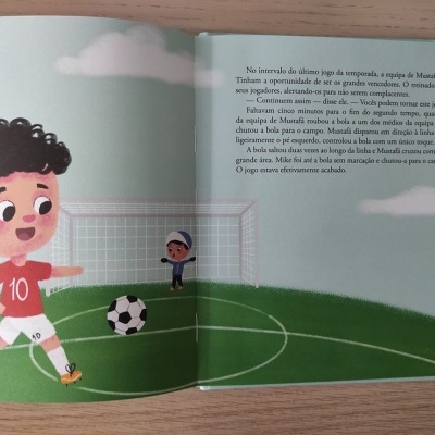 Ilustração de campo de futebol com criança a correr atrás de bola e texto em livro infantil