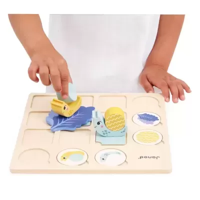 Tabuleiro de madeira com peças coloridas para encaixe, criança a brincar