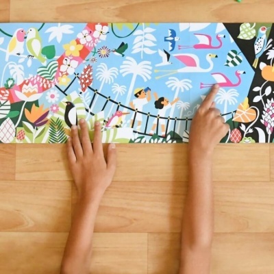 tapete infantil colorido com desenhos de animais, plantas e crianças sobre chão de madeira