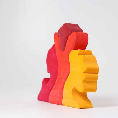 Três figuras de madeira coloridas em forma de perfis humanos empilhados