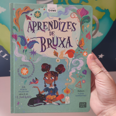 Capa do livro Aprendizes de Bruxa com ilustração de jovem bruxa e elementos mágicos coloridos