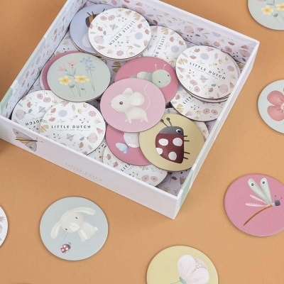 Peças redondas de madeira com desenhos de animais e insectos em caixa branca floral