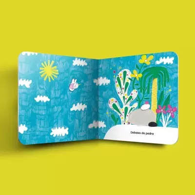 Livro infantil aberto com ilustrações coloridas e texto 'Debaixo da pedra'.