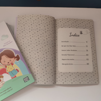Livro infantil aberto com índice e capa ao lado com ilustração colorida