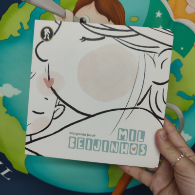 Capa do livro infantil 'Mil Beijinhos' com ilustração de mãe e criança em tons pastel