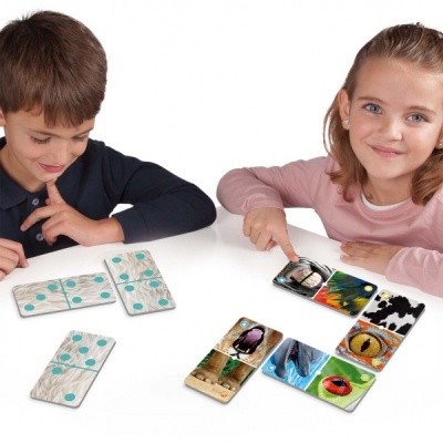 Crianças a jogar com dominós de madeira com padrões e imagens de animais.