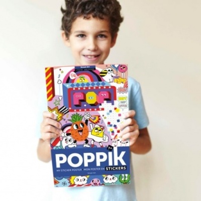Caixa colorida de stickers POPPIK com ilustrações e texto, segurada por uma criança