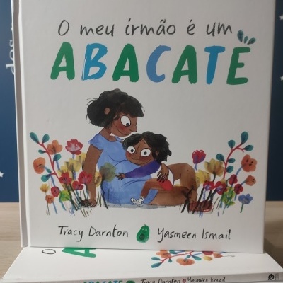 Capa do livro infantil 'O meu irmão é um ABACATE' com ilustração de mãe e filho entre flores.