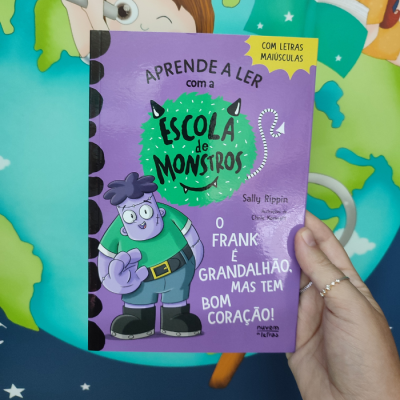 Livro infantil roxo com ilustração de monstro e texto educativo
