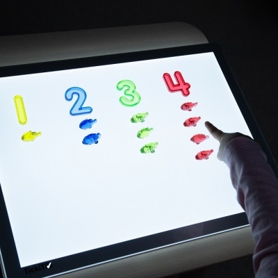 Mesa de luz com números e pegadas coloridas pintadas