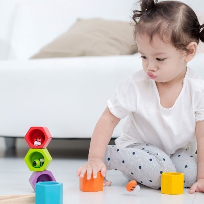 Criança a brincar com blocos de madeira coloridos no chão