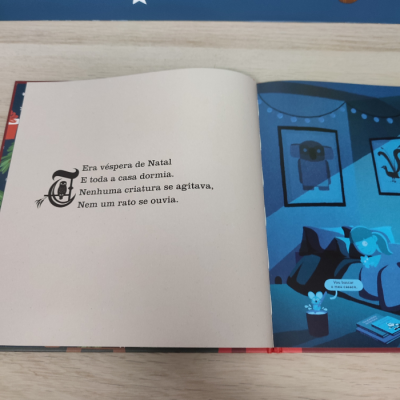 Página de livro infantil com texto de Natal e ilustração de rato num quarto azul