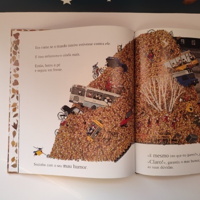 Página dupla de livro ilustrado com monte de pedras, veículos e texto em português