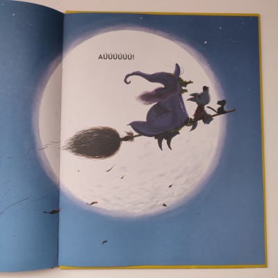 Ilustração de bruxa e corvo voando na vassoura diante da lua cheia com texto