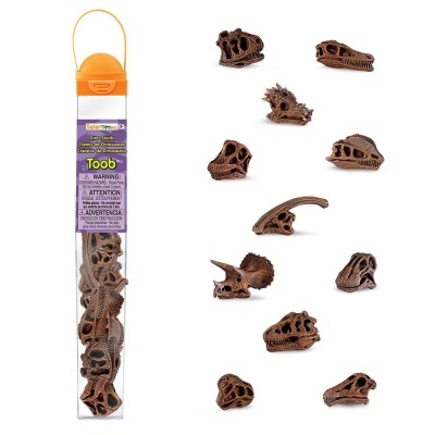 Miniaturas de crânios de dinossauros castanhos junto a embalagem plástica cilíndrica