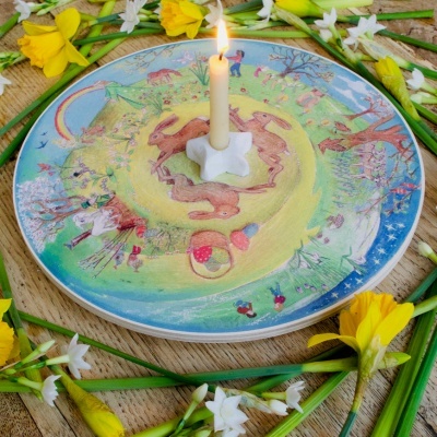 Prato cerâmico decorativo com vela e flores ao redor