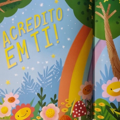 Ilustração colorida de livro infantil com texto 'EU ACREDITO EM TI!' e elementos naturais felizes