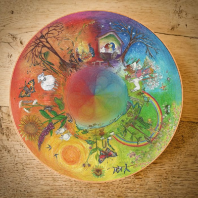 Prato redondo colorido com ilustração das quatro estações do ano e elementos naturais.