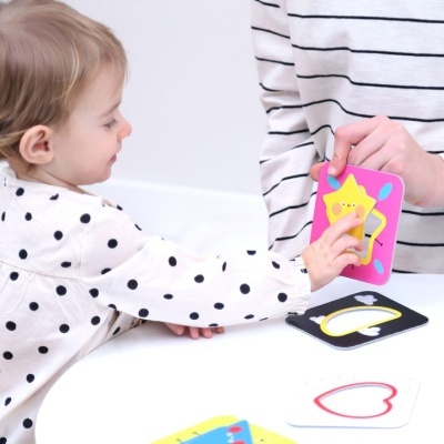 Criança a tocar carta de jogo colorida com estrela amarela feliz