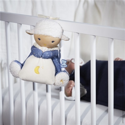 Brinquedo de cordeiro pendurado em berço de madeira branco
