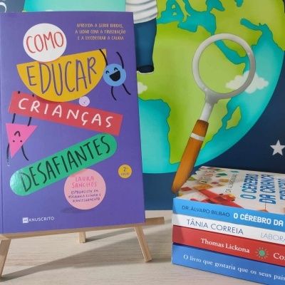 Livro educativo de capa roxa em cavalete com lupa e livros ao lado, fundo com planeta Terra.